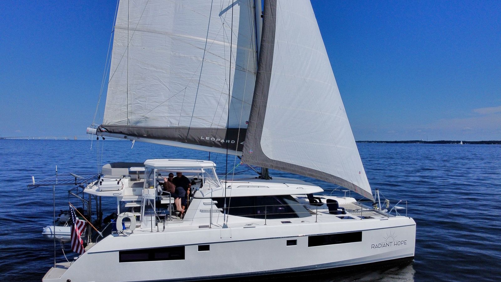 Catamaran under sail with Chesapeake Bay Bridge on horizon, starboard beam