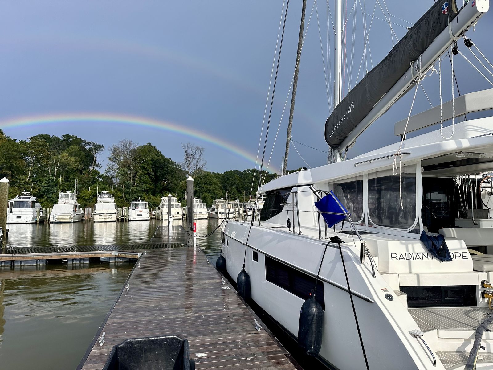 Dockside view with rainbow over tree line, LEOPARD 45 on boom cover